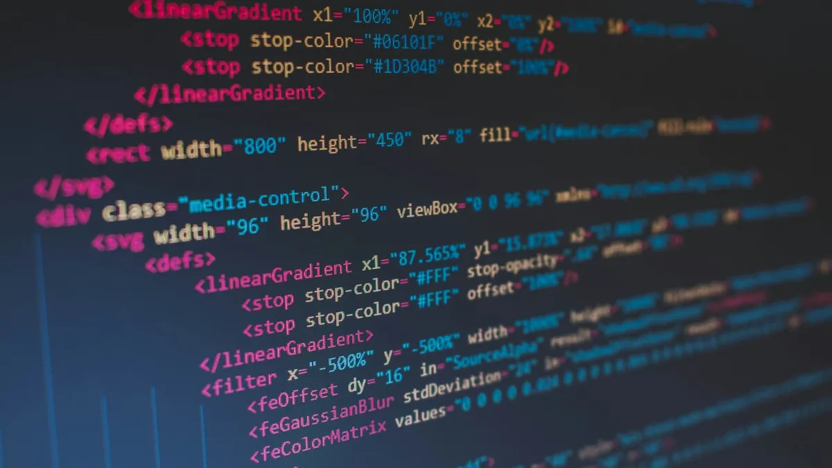 Lignes de code HTML colorées affichées en gros plan sur un écran sombre
